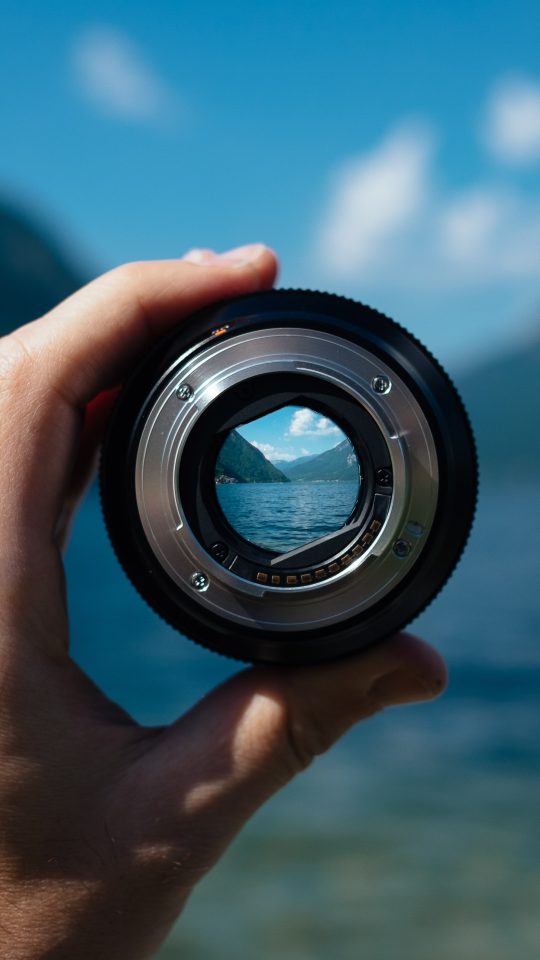person holding camera lens